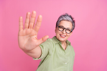 Closeup photo of pensioner good mood woman cheerful friendly showing five number waving palm hello symbol isolated on pink color background