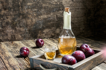Traditional Balkan plum brandy - rakija or rakia slivovica in the bottle, a wineglass with...