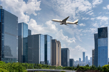 Fototapeta na wymiar plane fly over modern cityscape with office buildings and skyline.