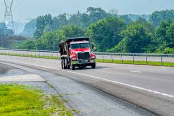 Fototapeta na wymiar Red Dump Truck On Access Road