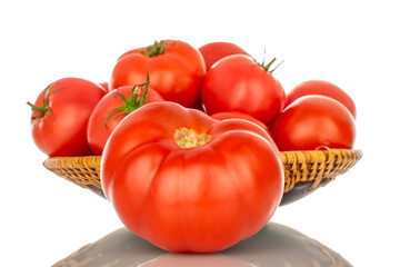 Several ripe red tomatoes in a ceramic plate, close-up, isolated on a white background.