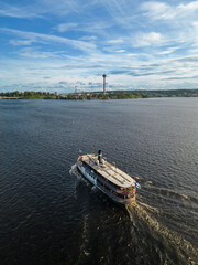 Fototapeta na wymiar An aerial view of a steamboat heading to port in Tampere, Finland