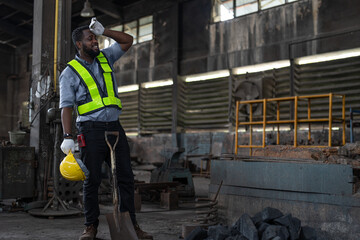 African American male worker wearing vest and helmet safety feeling tired from working hard after...