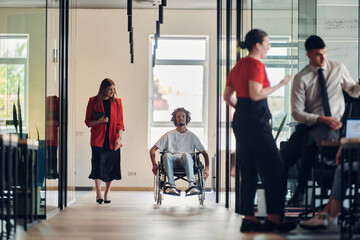 A group of young business people in a modern glass-walled office captures the essence of diversity...