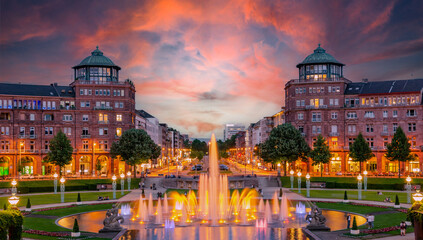 Mannheim, Germany. View on Friedrichsplatz at sunset with fountain creating splendid water and color effects. 2013-06-16. - obrazy, fototapety, plakaty