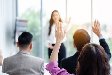Naklejka na ściany i meble Business person raising hand during seminar. Hand up in conference asking to answer a question in business meeting room and seminar class.