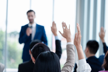 Business person raising hand during seminar. Hand up in conference asking to answer a question in...
