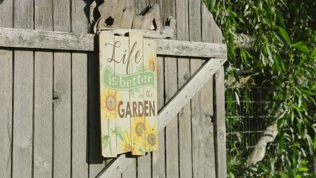 Close wraparound on garden gate with sign reading Life is Better in the Garden