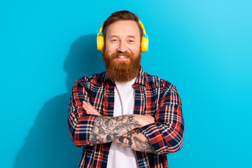 Photo of attractive millennial man red hair beard handsome model listening wireless earphones...