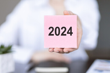 New year 2024 hand write on note sticker. New Goals, Plans, and Numbers for Next Year. Business strategy.