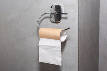 Empty roll of toilet paper in the bathroom. Last sheet of toilet paper. Emergency situation.