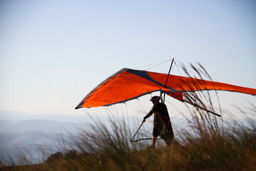 man preparing to take off with his hang glider - obrazy, fototapety, plakaty
