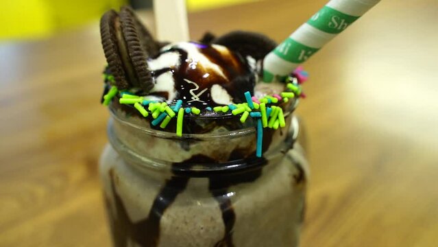 Double chocolate Oreo Milkshake in Indian Café closeup scene with blur background stock footage.