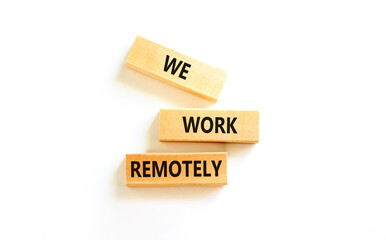 We work remotely symbol. Concept words We work remotely on wooden block. Beautiful white table white background. Business we work remotely concept. Copy space.