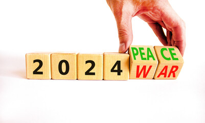 2024 war or peace symbol. Businessman turns a wooden cube and changes words 2024 War to 2024 Peace. Beautiful white table white background, copy space. Business 2024 war or peace concept.