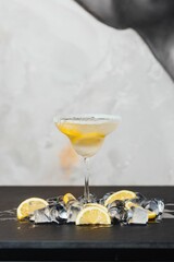 Close-up of a glass filled with tequila, topped with a sprinkle of salt and a freshly cut lemon