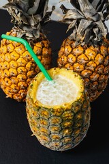 Delicious pineapple filled with a cocktail with a straw