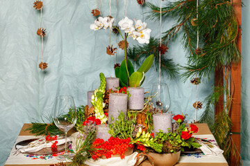 New Year's still life, thick candles among viburnum berries, spruce branches, white orchid flowers...