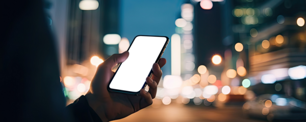 Hand holding smartphone with cut out screen on evening urban background