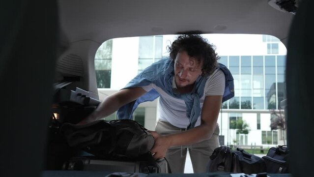 one man travel put stuff belongings to back of car prepare for travel