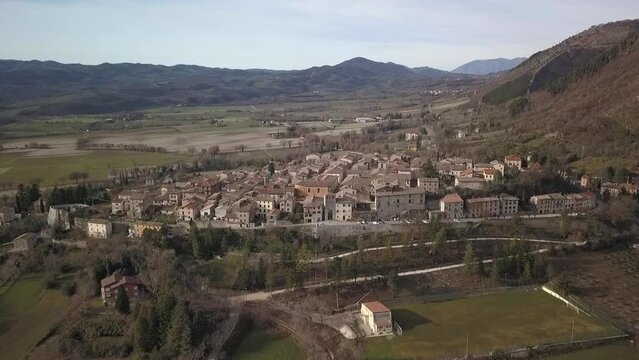 Aerial view of the old medieval village of Costacciaro in Italy surrounded by mountains