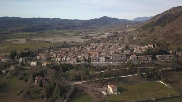Aerial view of the old medieval village of Costacciaro in Italy surrounded by mountains