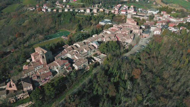 Aerial footage over traditional houses with vegetation trees forest in Sinalunga, Tuscany, Italy