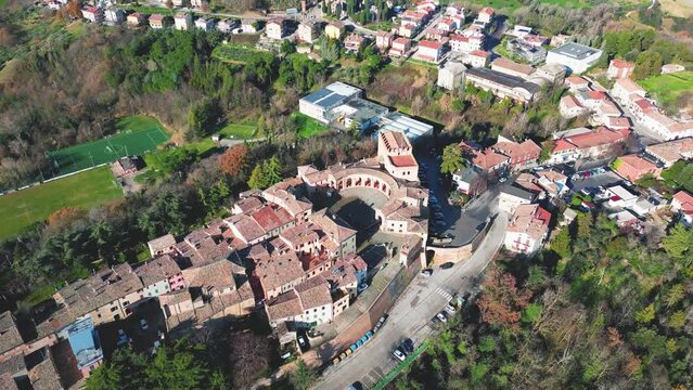 Aerial footage over traditional houses with vegetation trees in Sinalunga, Tuscany, Italy
