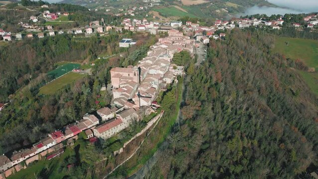 Drone footage over traditional houses with vegetation trees in Sinalunga, Tuscany, Italy