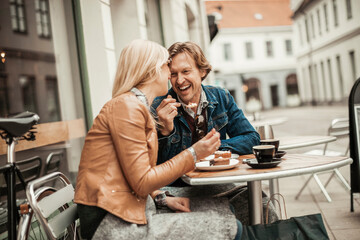 Middle aged couple drinking coffee at an outdoor cafe in the city