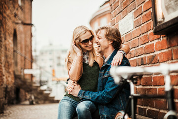Middle aged caucasian couple sitting on a bench in the city
