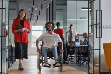 A group of young business people in a modern glass-walled office captures the essence of diversity...