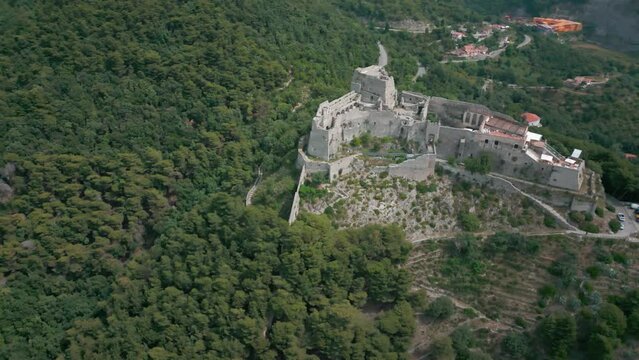 Drone shot over Arechi Castle on a green forested hill
