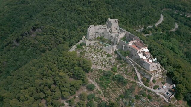 Drone shot over Arechi Castle on a green forested hill