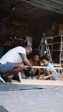 African American Father bonding with two sons over carpentry work
