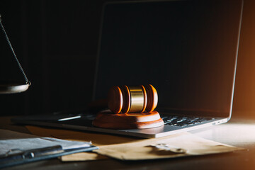 law legal technology concept. judge gavel on computer with scales of justice on desk of lawyer.