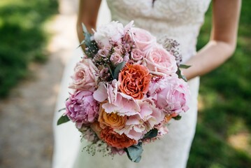 a bride holding a bouquet of flowers in her hands and a wedding gown