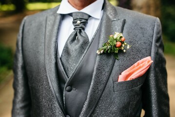a man in a suit with his pink pocket square bouthole on