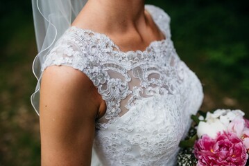 the bride has pink flowers in her hair and a veil