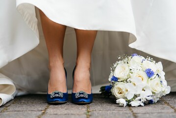 a bride wears a dress and shoes in blue with diamonds