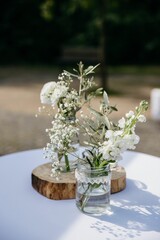 small vases filled with white flowers are set on a table