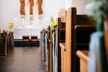 a view of flowers and candles sitting on pews at a church