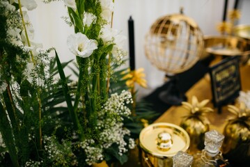 an elaborate table set up with candles, white flowers and gold decor