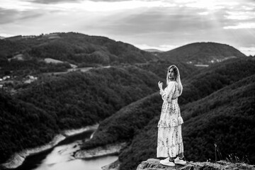 Black and white stock photo of a confident woman standing atop a hill