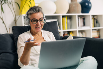 Caucasian senior woman is having an online meeting from home.