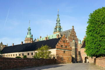 Fototapeta na wymiar External view of renaissance Frederiksborg castle, palace in Hillerod, Denmark, street to entrance