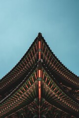 Fototapeta na wymiar Vertical shot of a traditional Korean building under the sunlight and a blue sky