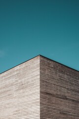 Fototapeta na wymiar Vertical shot of a modern building angle under a blue sky and sunlight