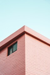 Vertical shot of a modern building angle under a blue sky and sunlight