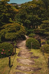 Vertical shot of a majestic Japanese garden covered in flowers and greenery in Japan